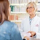 Apothekerin nimmt Rezept in der Hohenzollern Apotheke entgegen