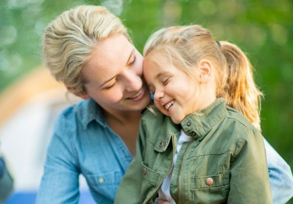 Mutter und Kind mit Hämophilie lachen sich an