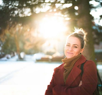 Zwei junge Frauen, Mitarbeiterinnen im Kompetenzzentrum Blase und Darm der Hohenzollern Apotheke schauen sich an einem Schreibtisch Fertigspritzen zur Instillation in die Blase an. Das Bild ist von leicht unten fotografiert.